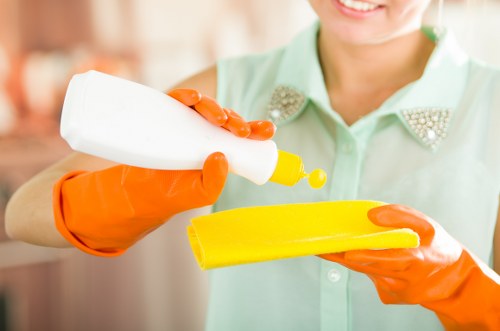 Professional cleaner working in a modern Uxbridge kitchen and bathroom